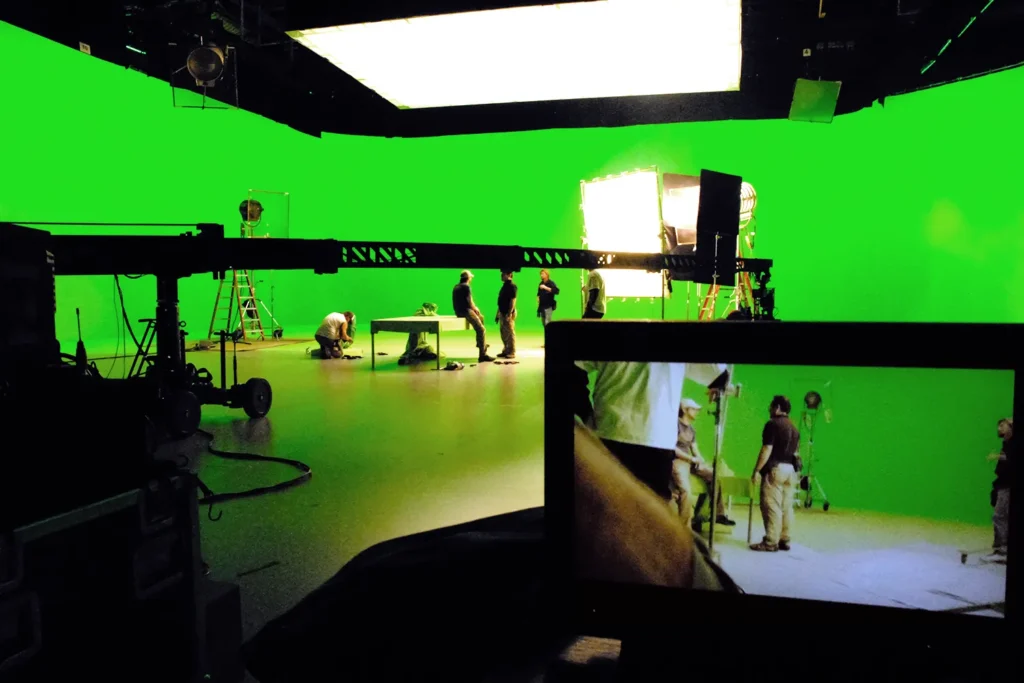 A film crew setups up for a green screen shoot.